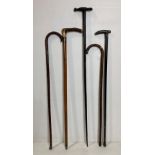 Five assorted walking sticks, four with silver collars,