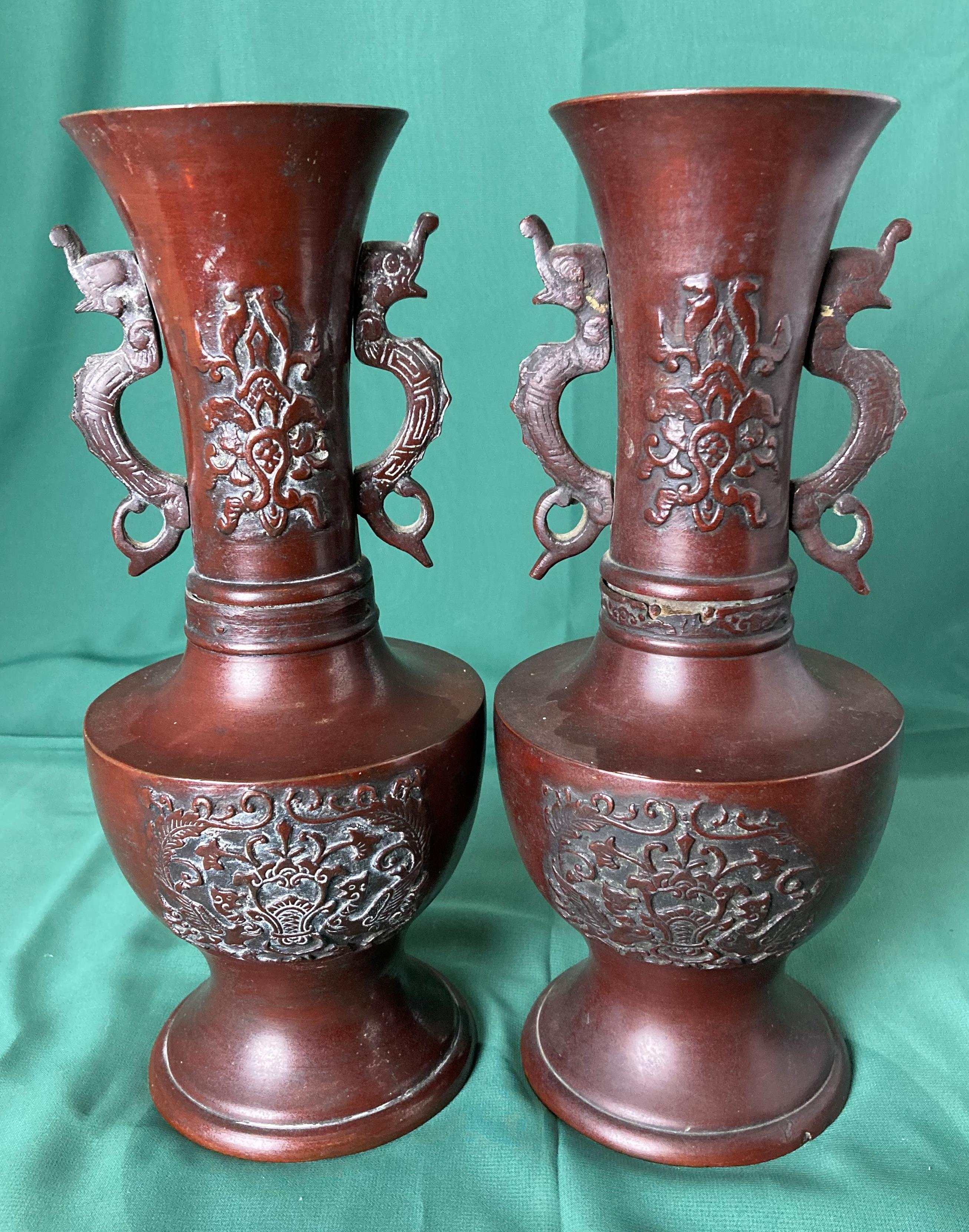 A pair of bronze vases with dragon handles and dragon and foliage design (26cm high),