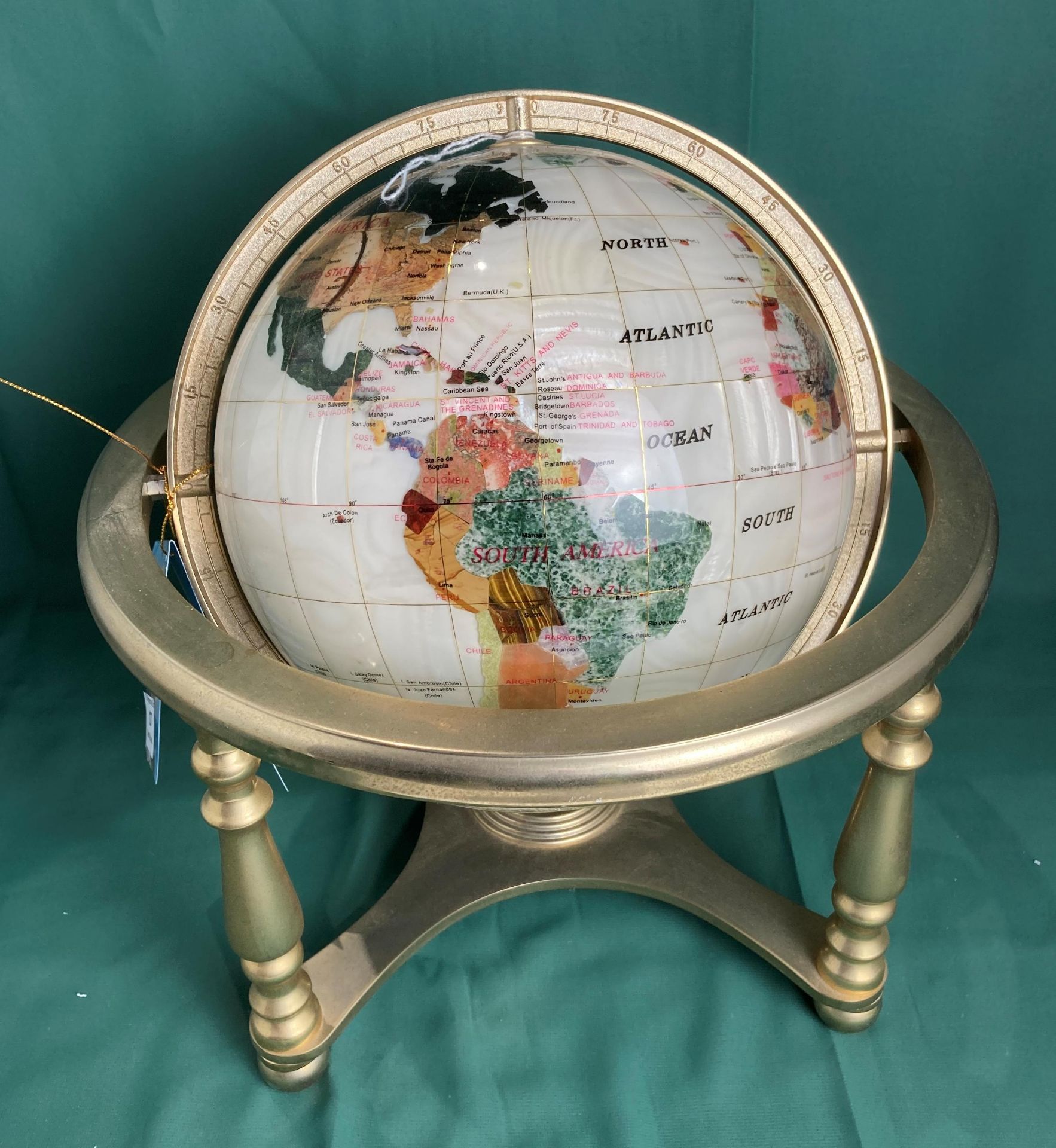 Gem stone globe on brass stand,