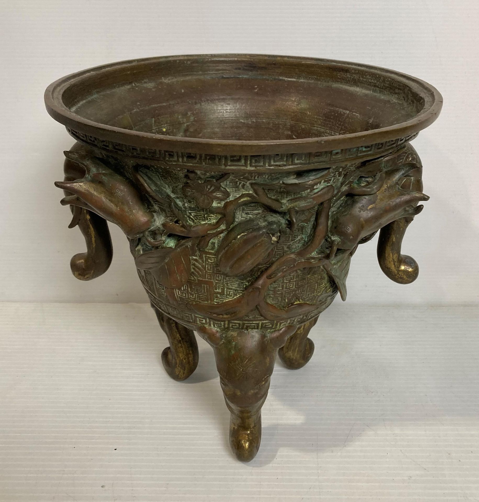 An Oriental bronze incense burner with elephant head legs and two elephant head handles with