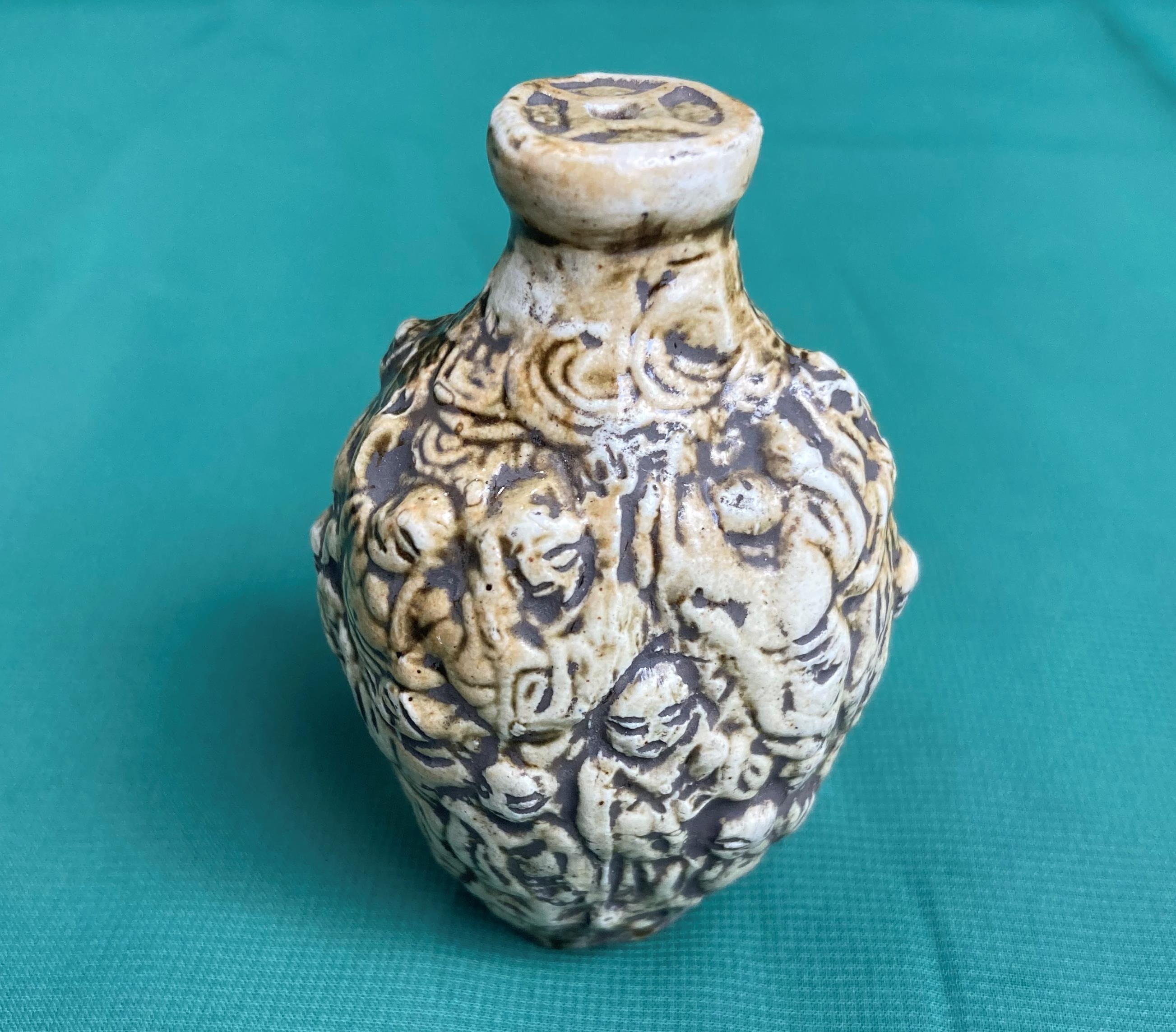 An antique hand-carved stone snuff/scent bottle decorated with Buddha and monks,