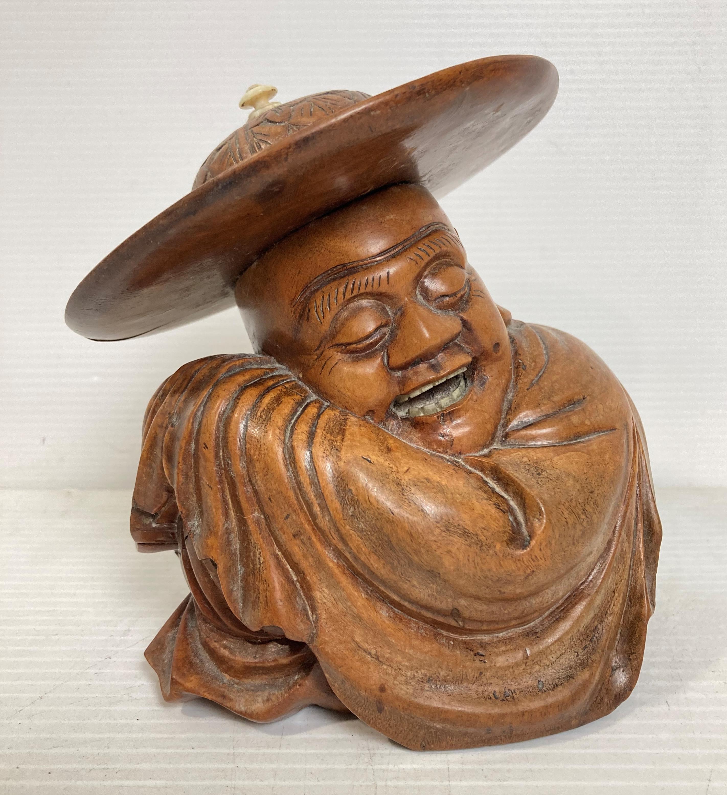 An Oriental wooden hand-carved figurine of sleeping man with engraved hat,