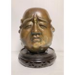 An antique Oriental bronze four-face Buddha head with four-symbol stamp to base on a hand-carved