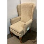 A 'Shackletons' high wing-back armchair in an oatmeal fabric on cabriole legs (saleroom location: