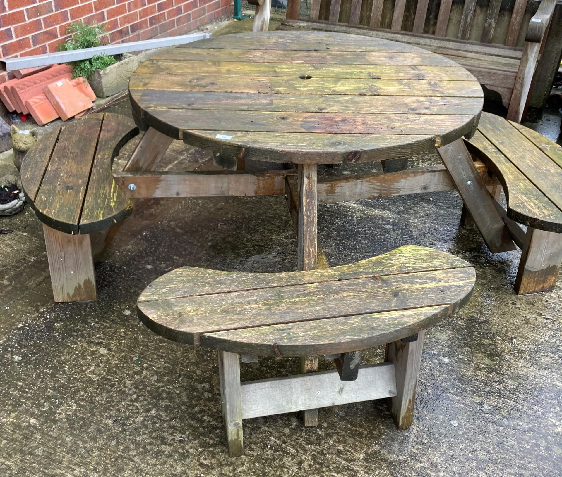 A circular wood garden bench with four seats (115cm diameter) with seats (180cm diameter) (saleroom