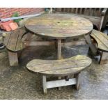 A circular wood garden bench with four seats (115cm diameter) with seats (180cm diameter) (saleroom