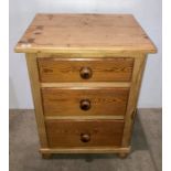 A stripped pine large three-drawer bedside unit,