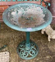 A green painted metal bird bath on stand,