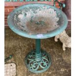 A green painted metal bird bath on stand,