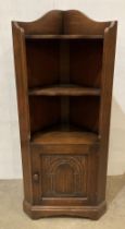 Oak corner cabinet with single door with carved panel and three shelves,