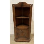 Oak corner cabinet with single door with carved panel and three shelves,