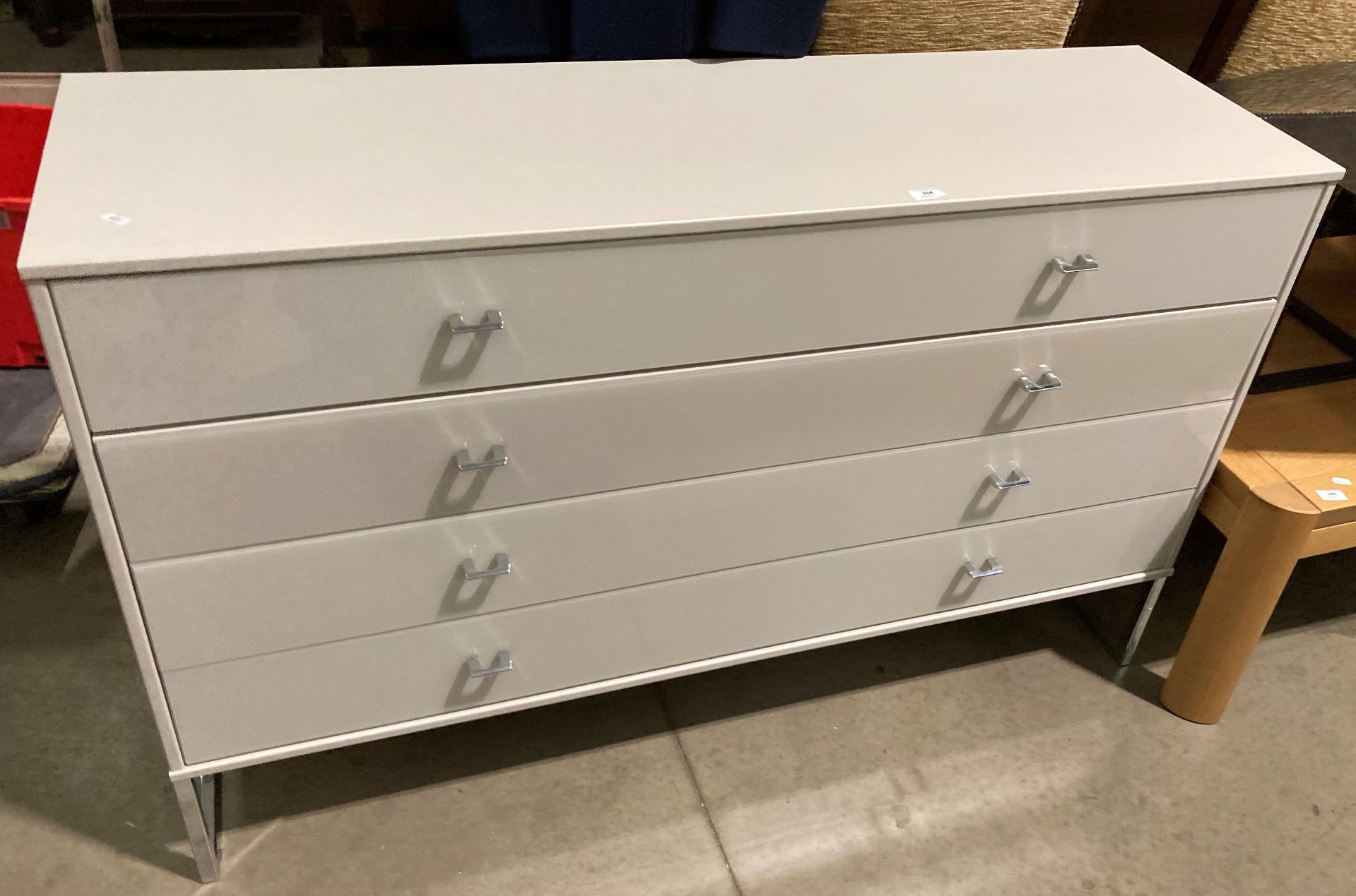 A light grey melamine long chest of drawers with four perspex covered drawers (142 x 43 x 89cm