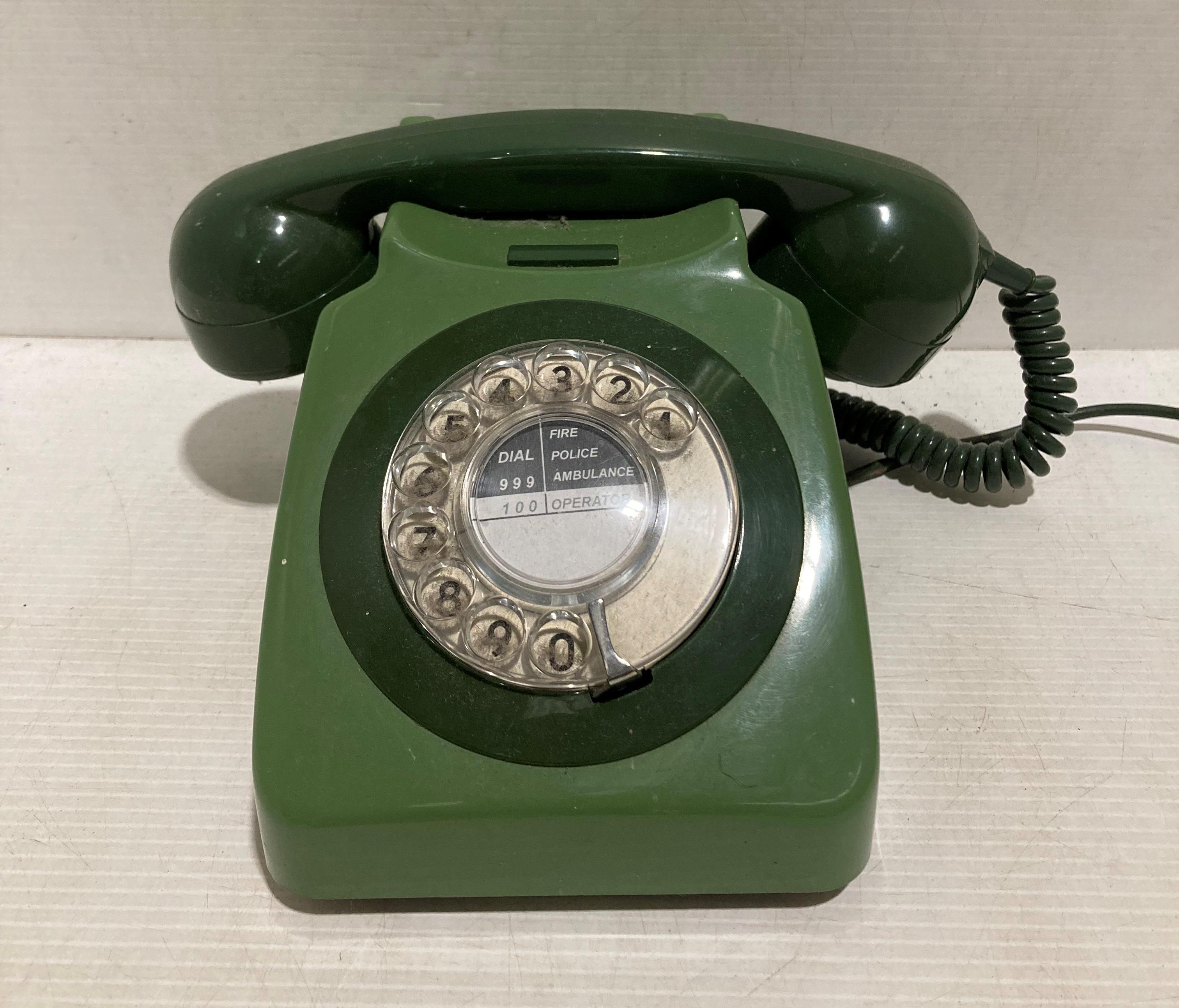 A green plastic turn dial telephone,
