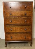 An oak five-drawer chest of drawers with printing block handles on cabriole legs,