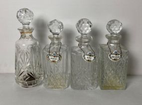 Four assorted cut crystal decanters, three with Crown Staffordshire decanter tags for gin,