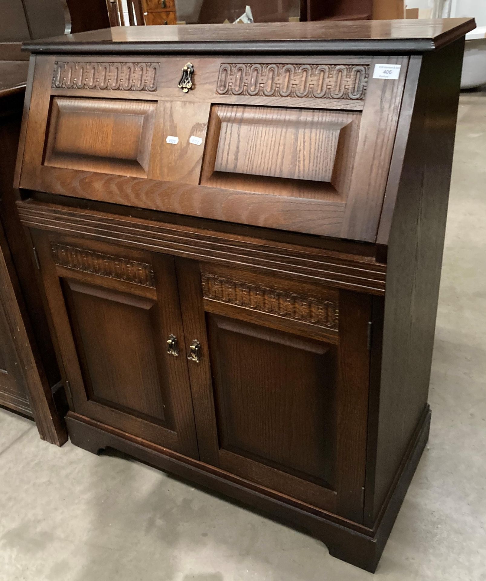 An oak bureau with fall-flap over two-door base,