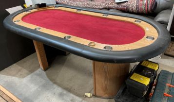 A wood-framed oval gaming table with black vinyl protective rim and red velvet-effect top,