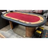 A wood-framed oval gaming table with black vinyl protective rim and red velvet-effect top,