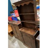 An oak thin dresser with two shelves over single door base,