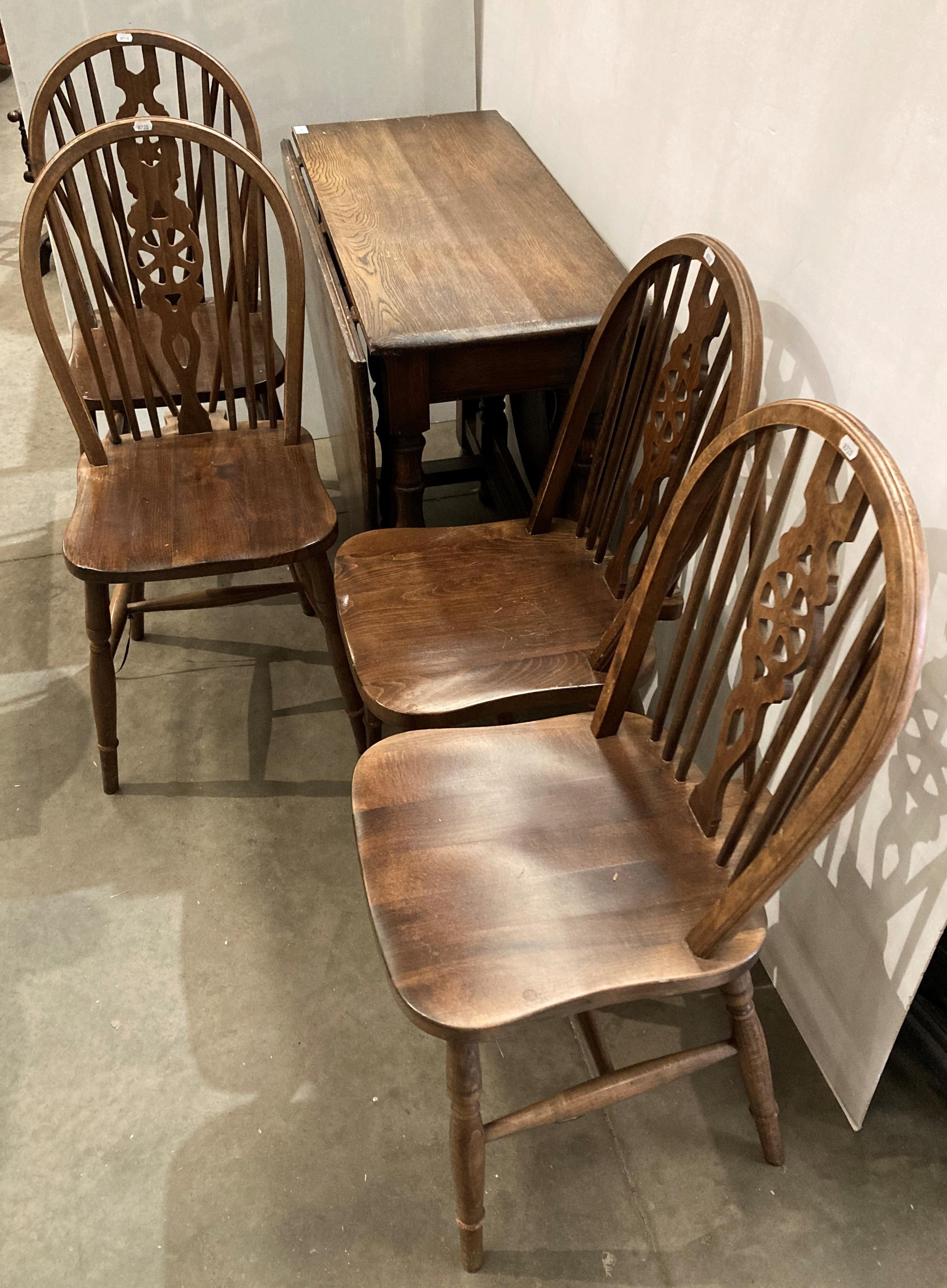 Oak oval drop-leaf gate-leg dining table and four wheel-back dining chairs,