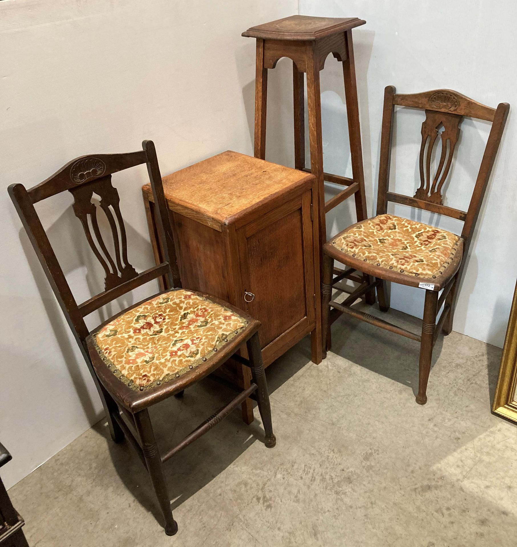 A pair of mahogany bedroom chairs with turned legs and carved back panel,