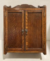 An oak wall hung two-door smoker's cabinet with internal drawer,