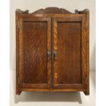 An oak wall hung two-door smoker's cabinet with internal drawer,