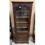 A walnut two-door slim bookcase with single six-panel door (one panel cracked) and a lower door,