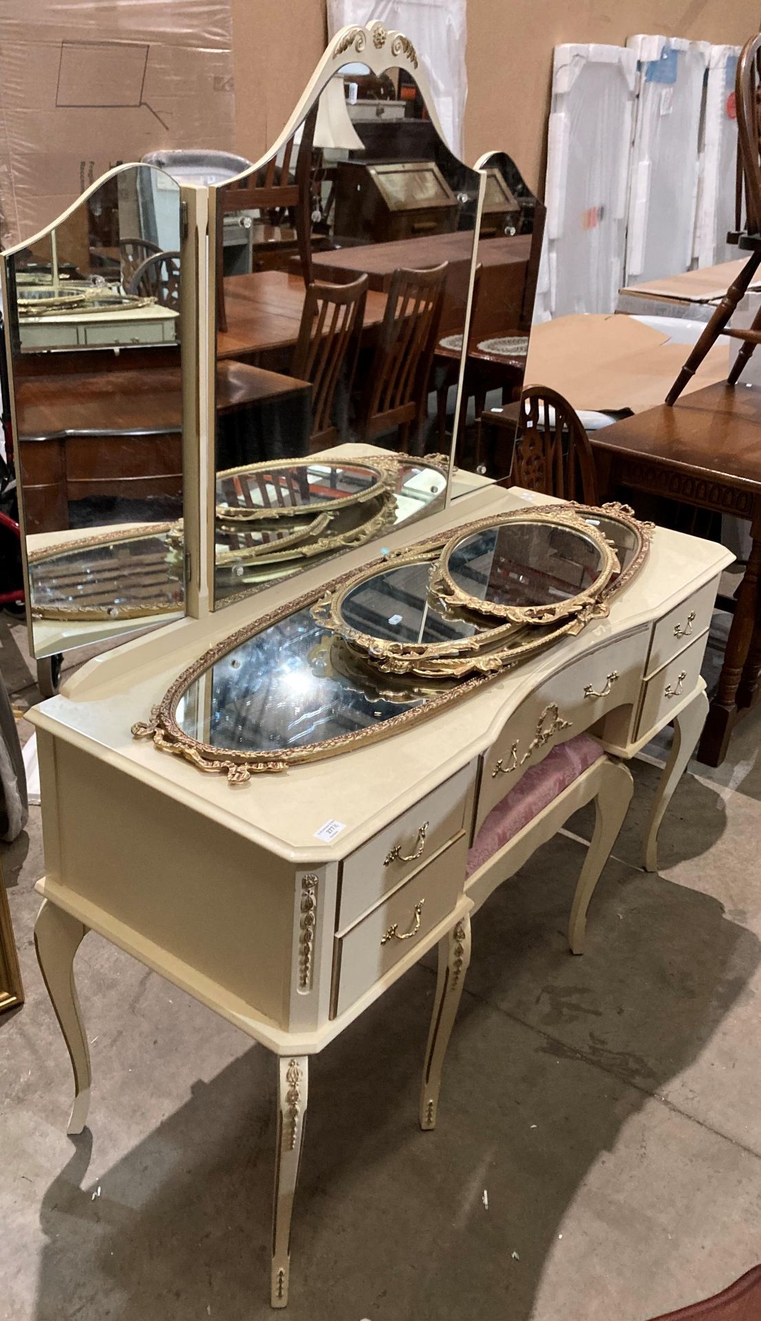 A cream painted continental-style triple mirror-back dressing table (125cm long) complete with