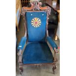 A Victorian ornate framed walnut armchair with dark blue upholstery with centre circle motif