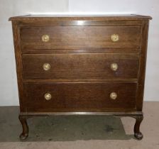 An oak three-drawer chest of drawers on cabriole legs,