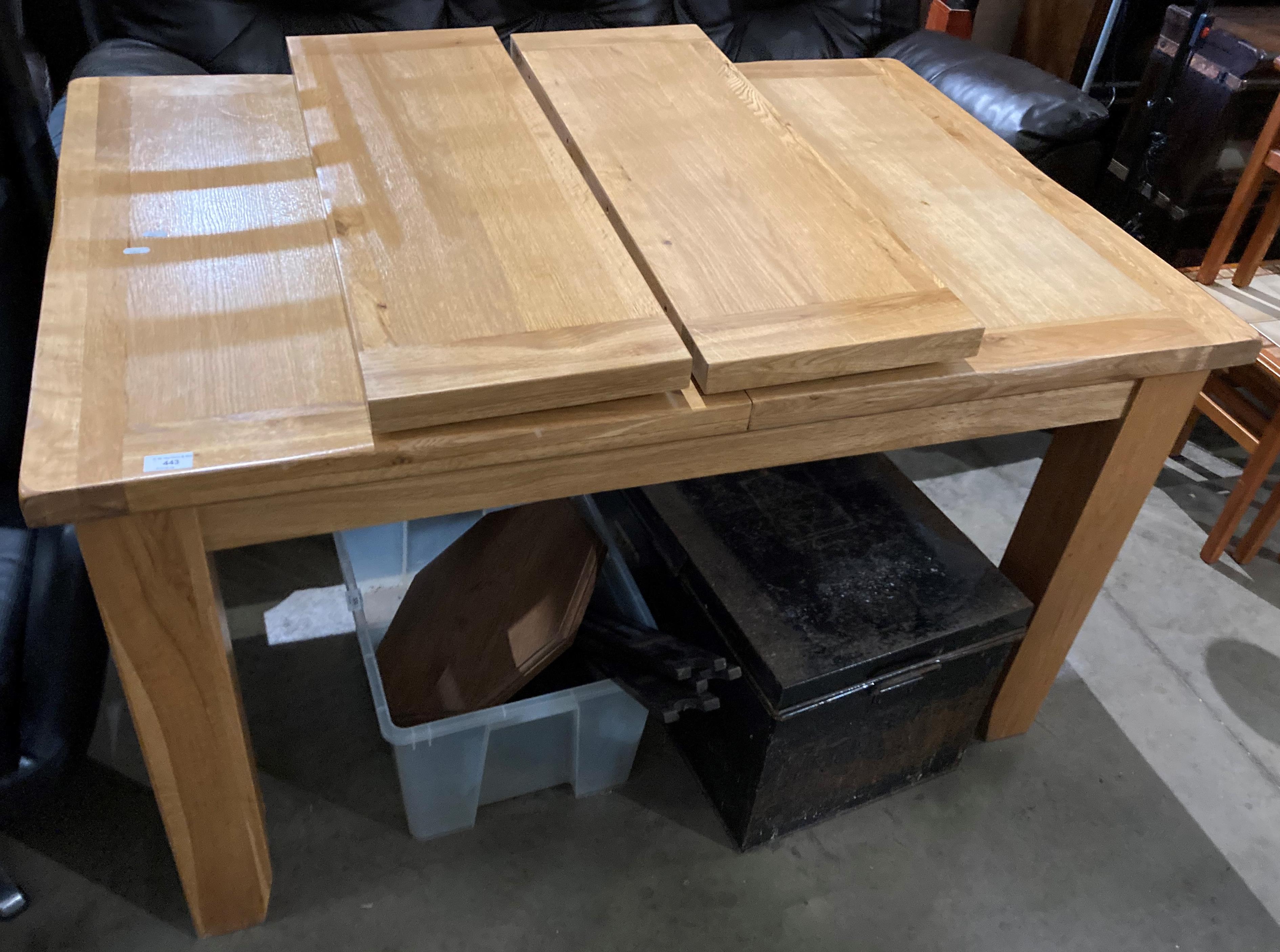 A light wood extending dining table with two leaves,