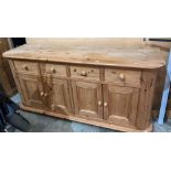 A pine sideboard with four drawers and four doors,