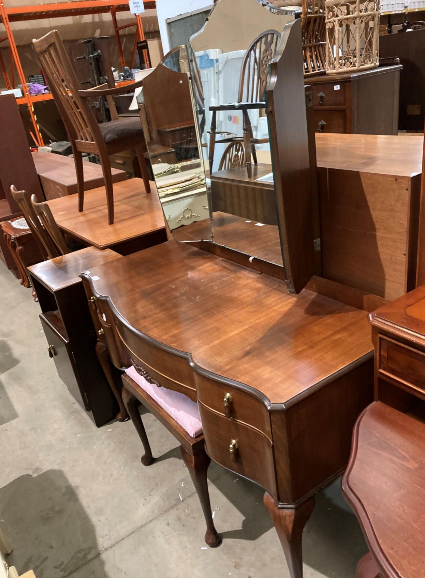 A mahogany shaped front five drawer mirror-back dressing table (120cm long) complete with matching