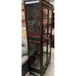 A modern dark wood finish display cabinet with three glass shelves, two under-drawers and lighting,