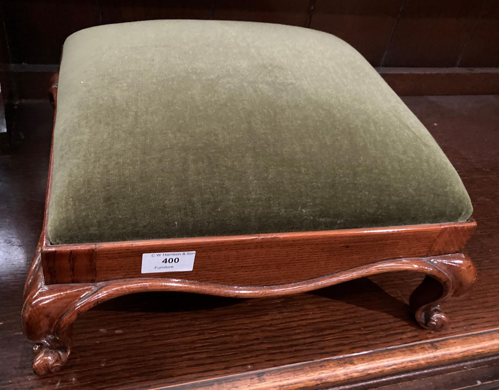 An oak footstool with claw feet and green upholstered seat (saleroom location: MA2)