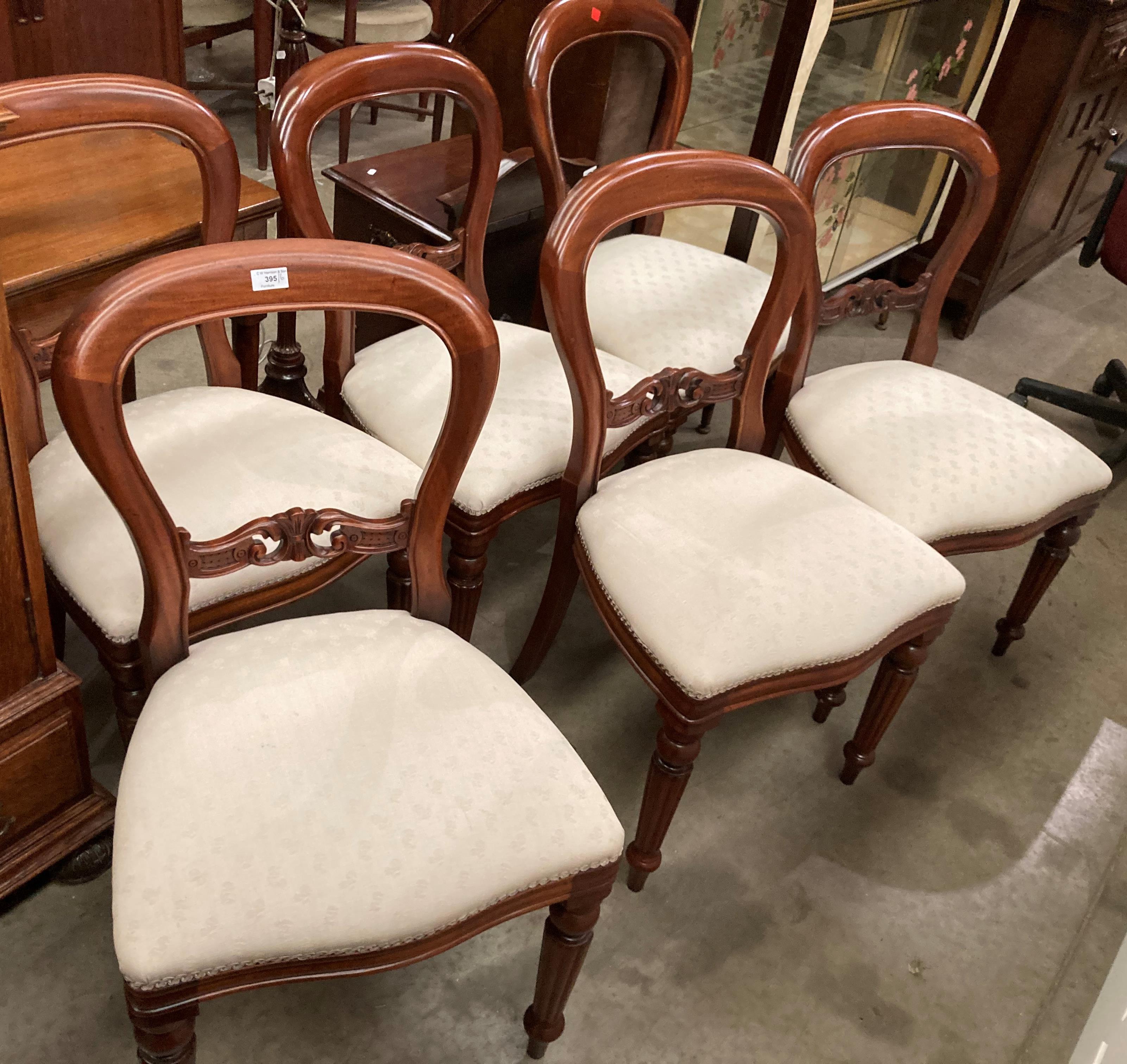 A set of six mahogany balloon back dining chairs with beige upholstered seats,