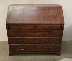 A Georgian large oak bureau with four long drawers and drop-front door revealing eight internal