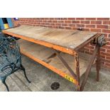 A metal framed two-tier work-bench with plywood shelves and fitted with a vice,