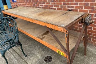 A metal framed two-tier work-bench with plywood shelves and fitted with a vice,