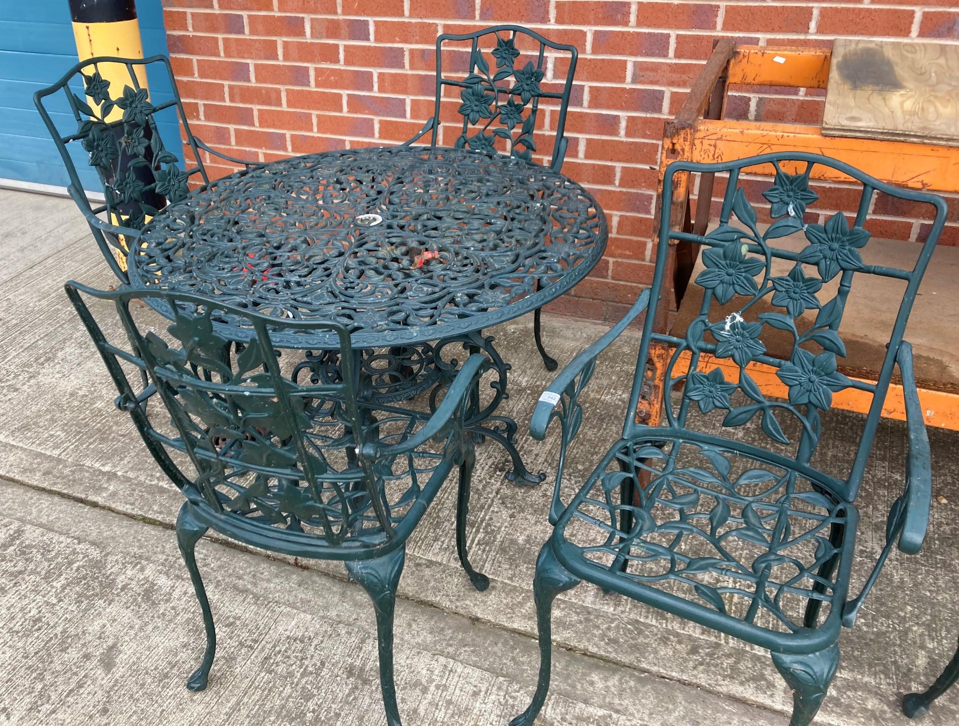 A green painted aluminium garden patio set comprising circular table (100cm diameter) and four