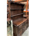 An oak dresser with two open shelves over two-drawer, two-door base,