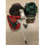 Green fabric fishing bag and assorted accessories including feeders, weights, nets,