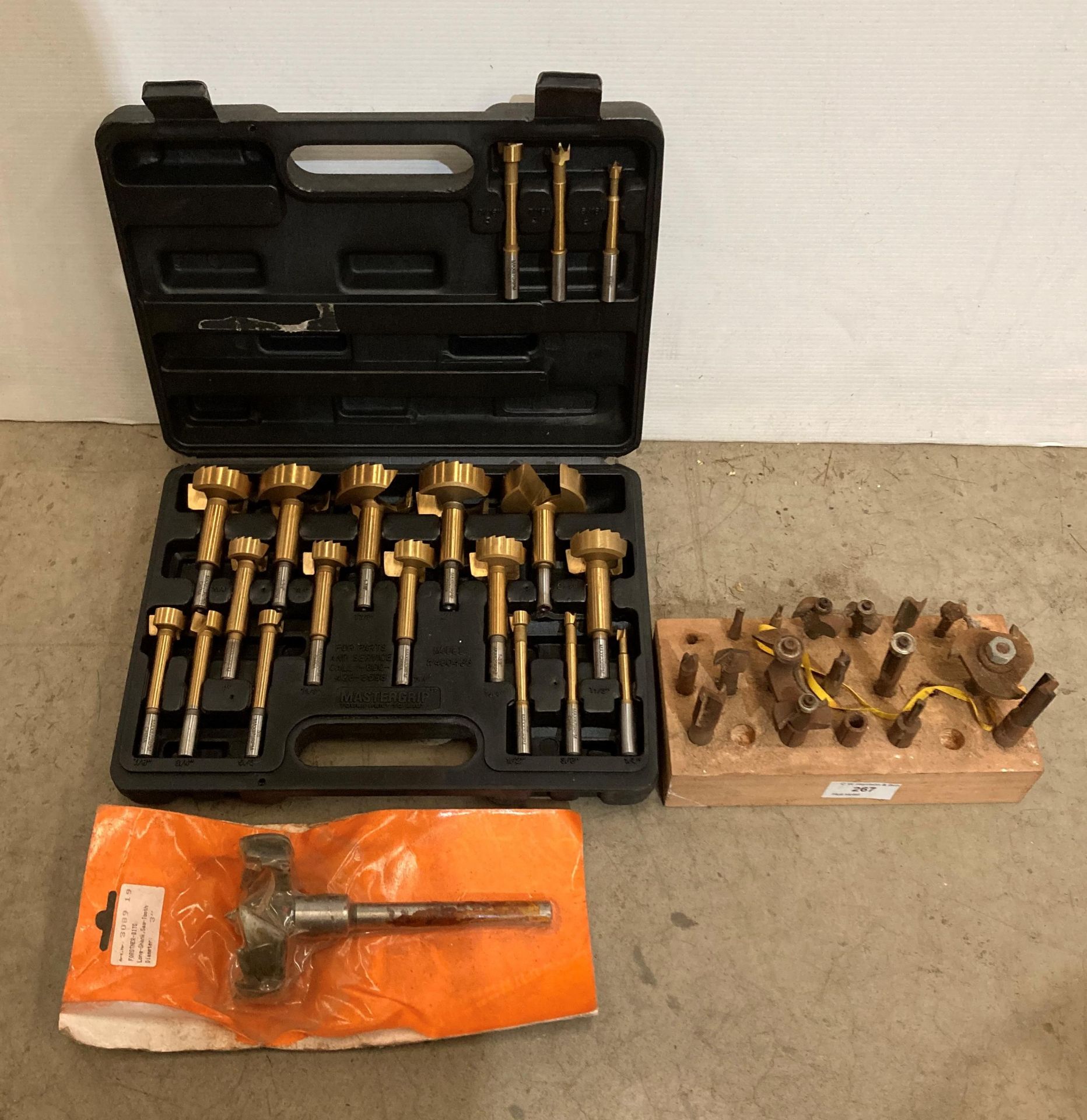 A cased set of 19 Mastergrip titanium-plated forstner bits and a 16-piece router set in black