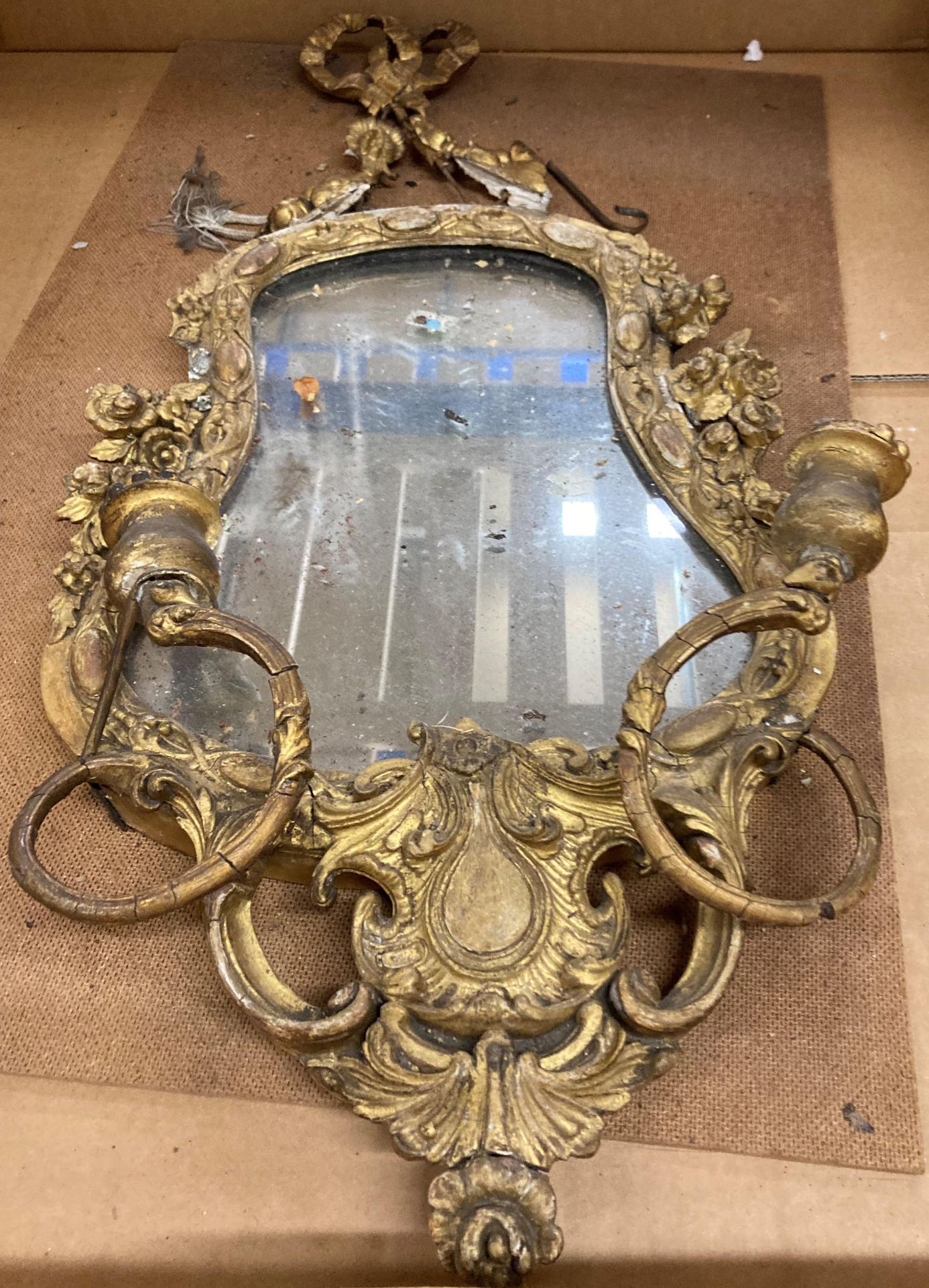 A 19th Century ornate gilt framed wall mirror - with damages - approximately 57cm x 34cm (sold as