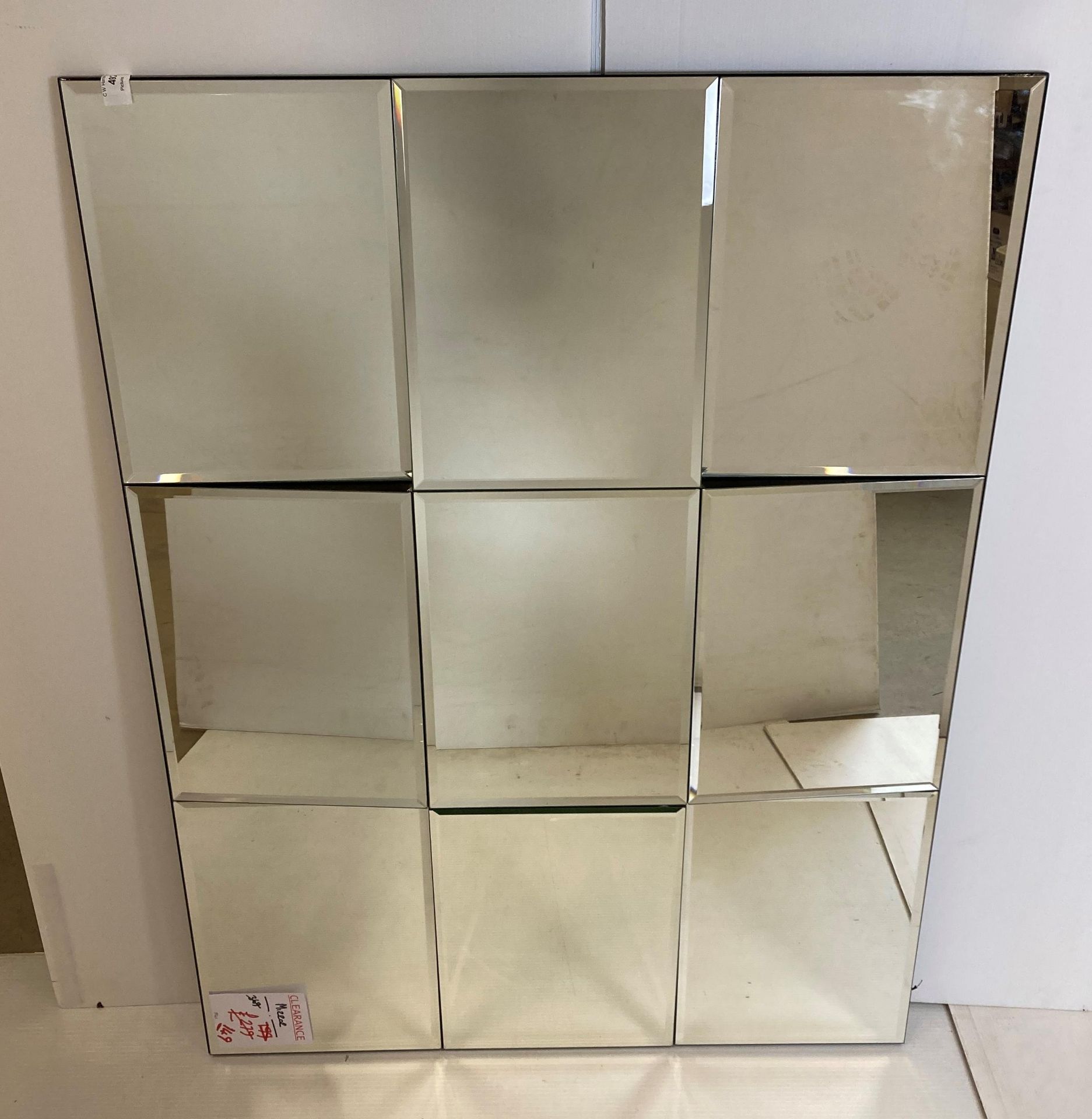 Large rectangular mirror wall display with nine mirrors, set at varying angles,