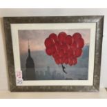 Print of New York balloons in dark wood frame,