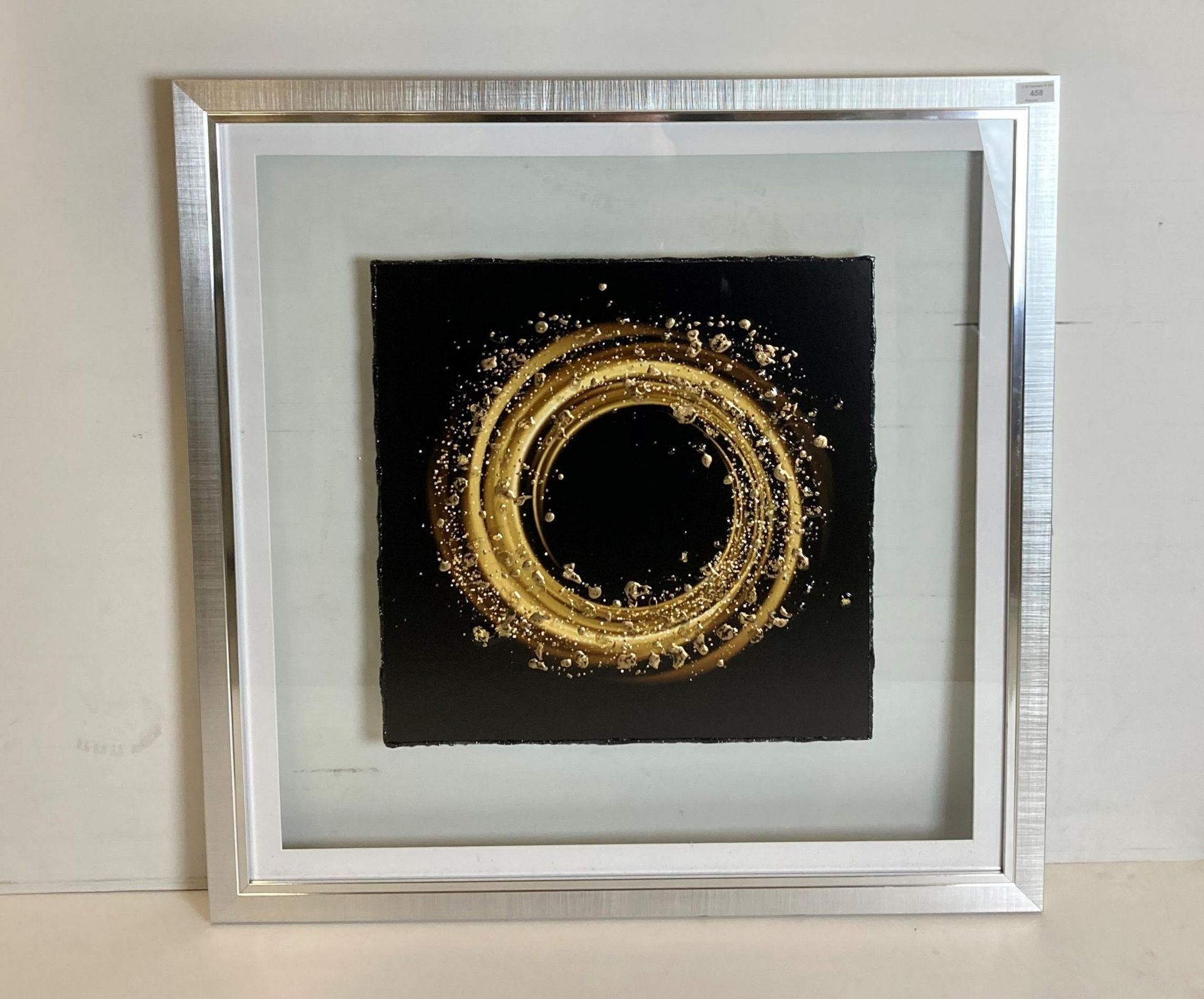 Liquid crystal circular artwork 'Solid Stardust' in chrome surrounded by glass frame,