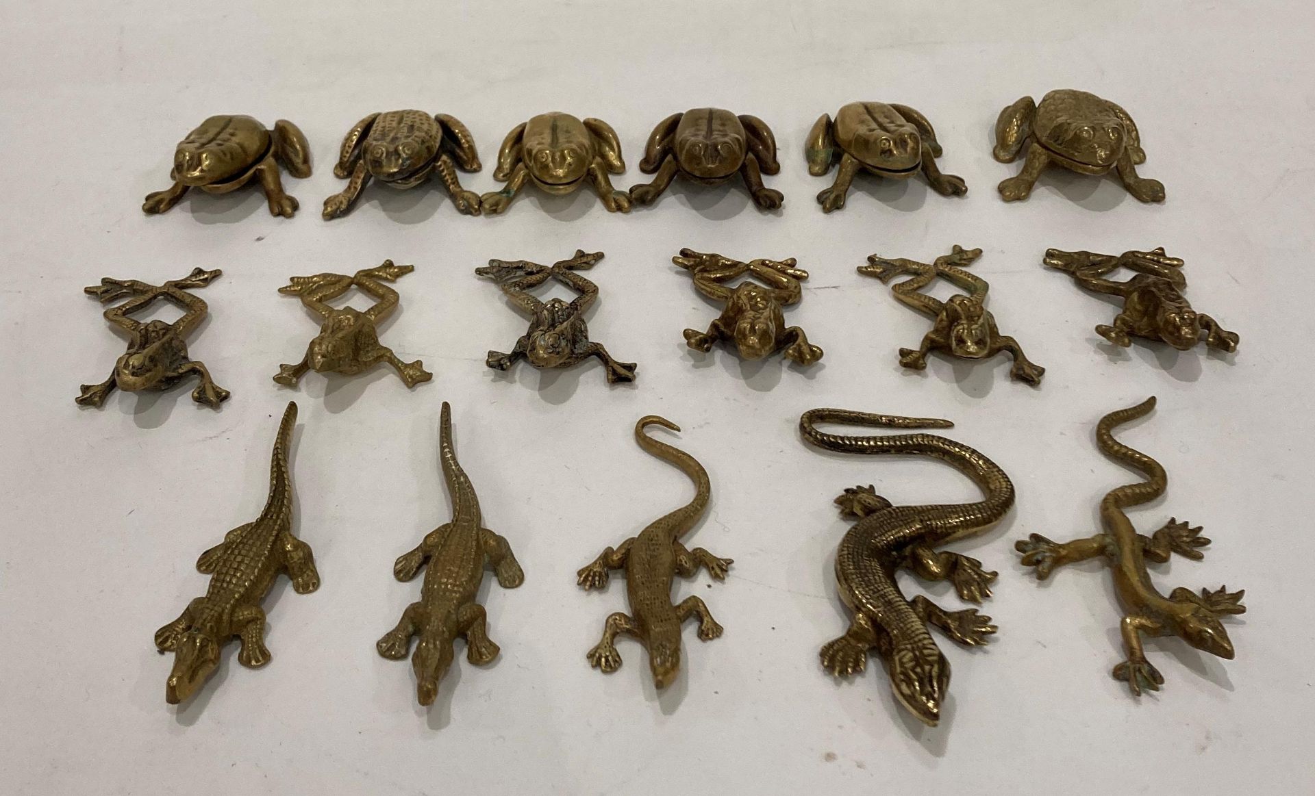 Seventeen brass animals including twelve frogs/toads, crocodiles and lizards,