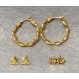 Two pairs of 9ct gold earrings - a twisted hoop pair and a flower stud pair together with a pair of